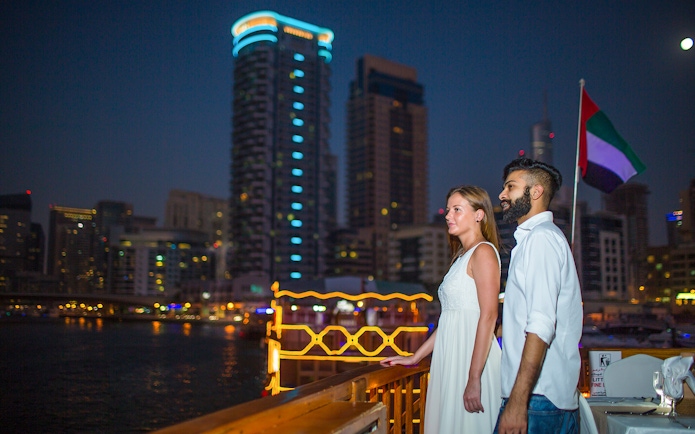 Couple enjoying Marina skyline from Alexandra VIP Dhow Cruise in Dubai.