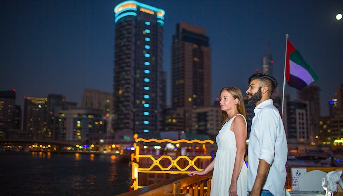 Couple enjoying Marina skyline from Alexandra VIP Dhow Cruise in Dubai.