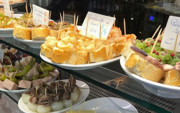 Venetian cicchetti with seafood and toppings on display during a street food tour in Venice.