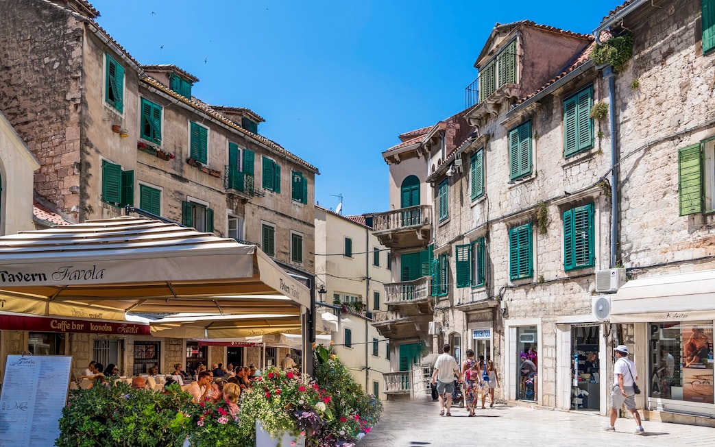 Historic street scene in Split, Croatia, with cafes and ancient stone buildings in Diocletian's Palace.