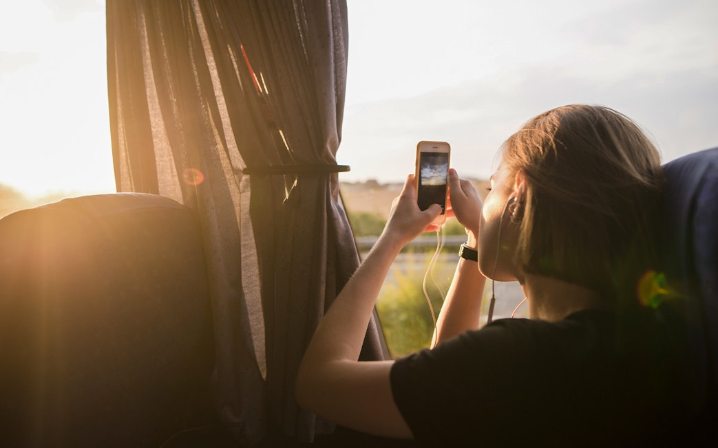 Tourist taking photo from bus window on early morning trip to Chichen Itza.