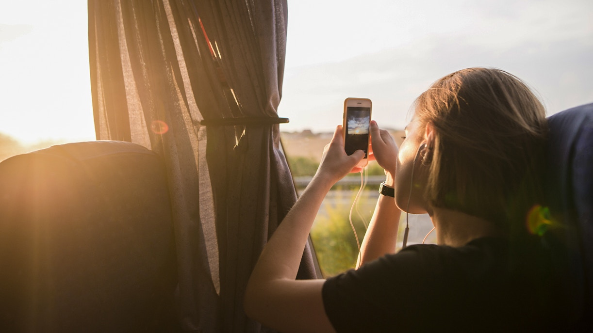 Tourist taking photo from bus window on early morning
