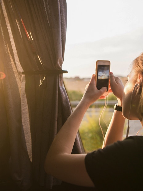 Tourist taking photo from bus window on early morning trip to Chichen Itza.