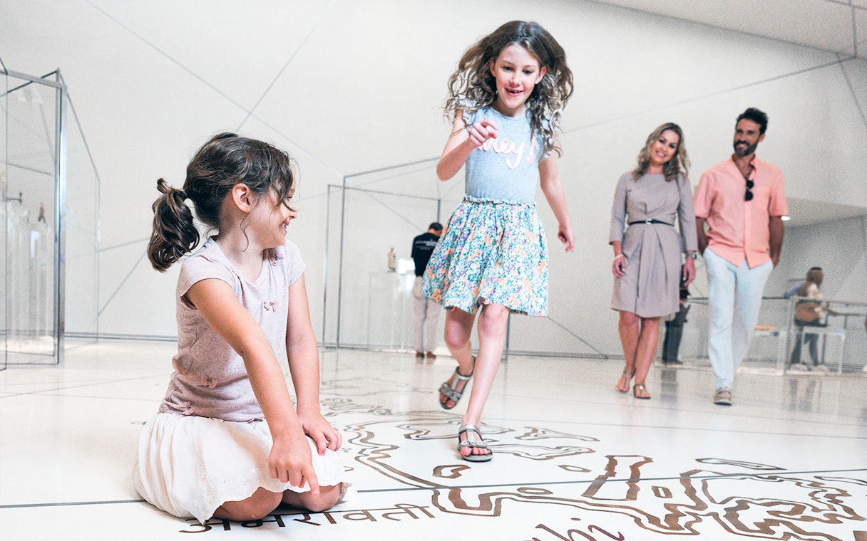 Visitors enjoying interactive exhibits at the Louvre Museum Abu Dhabi.