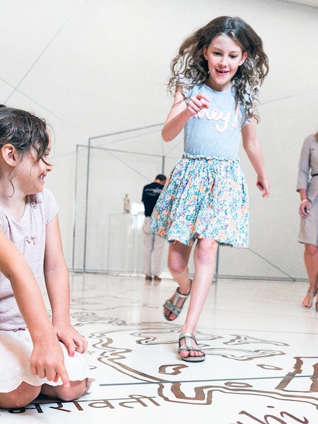 Visitors enjoying interactive exhibits at the Louvre Museum Abu Dhabi.