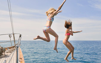 People jumping off a boat into the sea during a Half Day Athens Cruise.