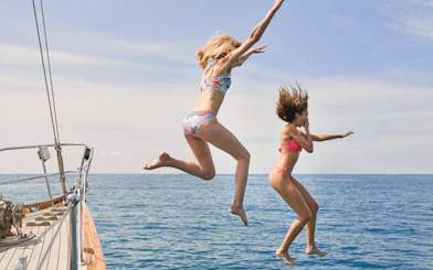 People jumping off a boat into the sea during a Half Day Athens Cruise.
