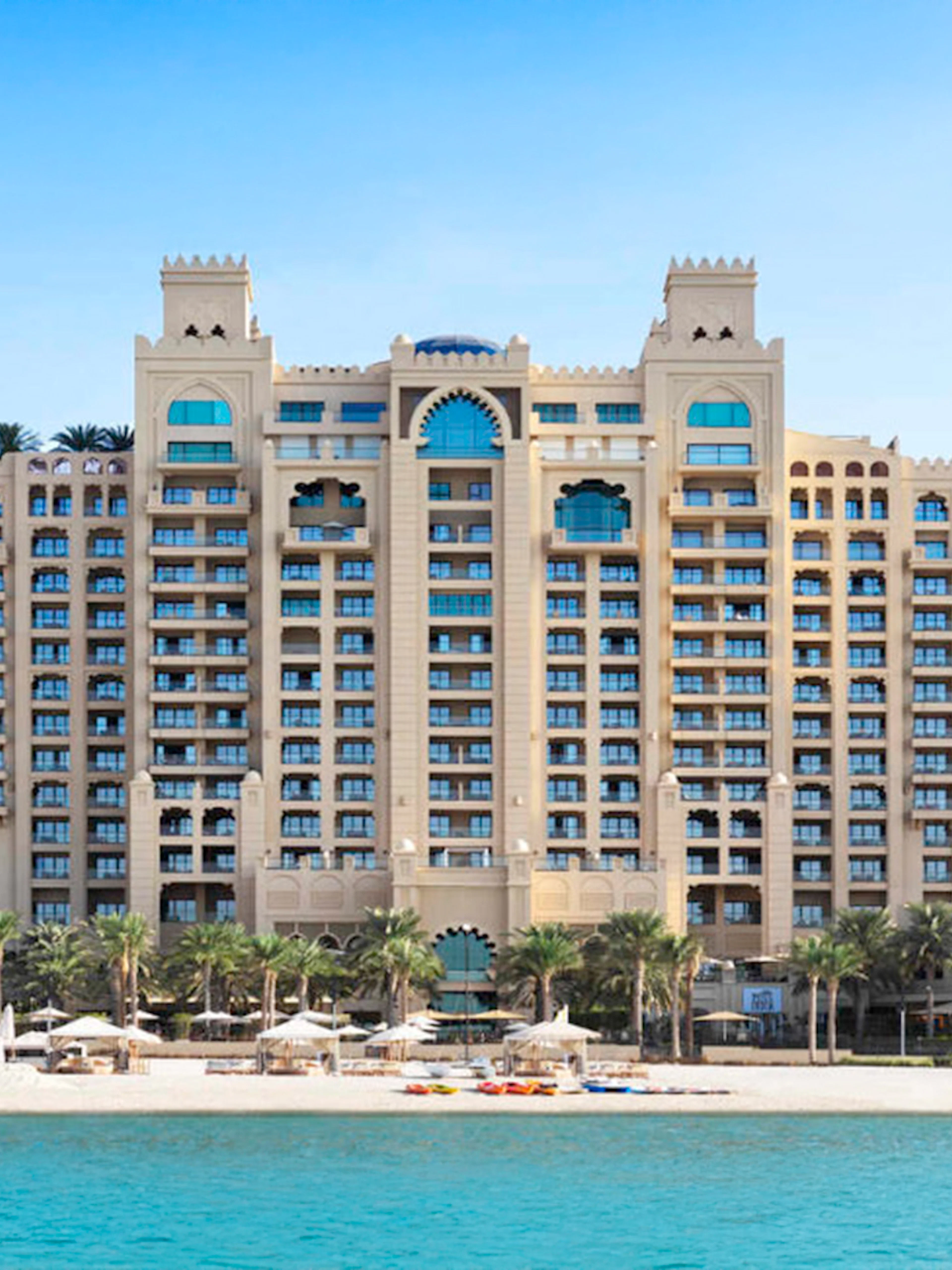Fairmont Hotel beachfront view with palm trees and blue sea.