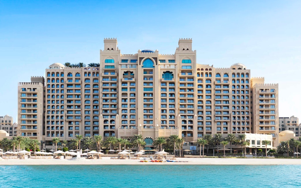 Fairmont Hotel beachfront view with palm trees and blue sea.