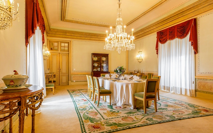 Dining room in D Maria Pavilion, National Palace of Queluz, featuring a chandelier and set table.