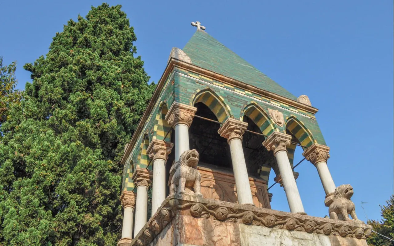Medieval tomb with lion statues in Bologna, Italy, part of self-guided city exploration game.