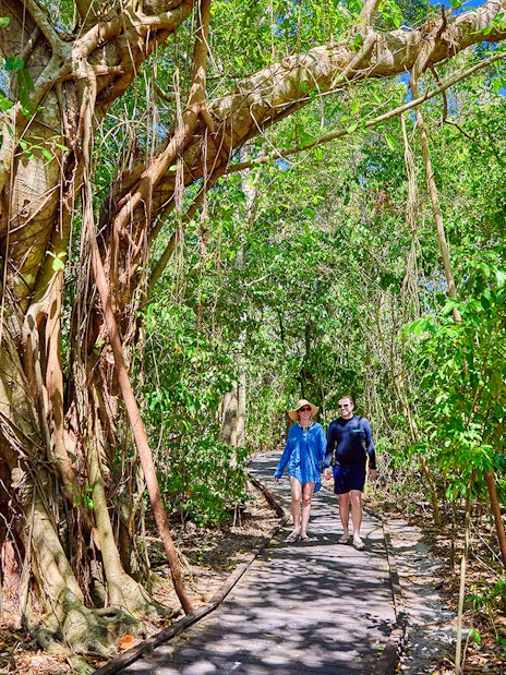 Couple walking on a forest path on Fitzroy Island, surrounded by lush greenery.