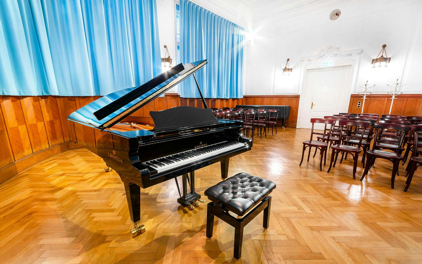 Grand piano in Ehrbarsaal concert hall, Vienna, with rows of chairs for Amadeus Concerts.