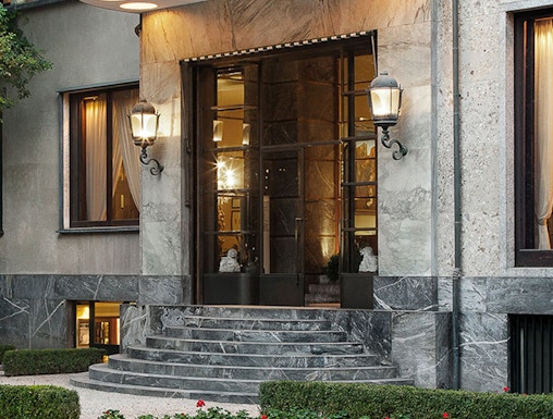 Entrance of Villa Necchi Campiglio in Milan with stone steps and garden.
