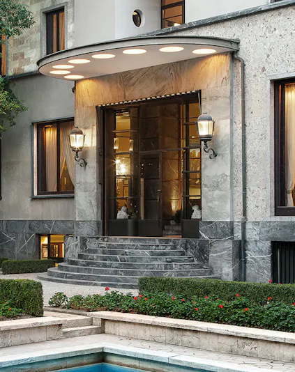 Entrance of Villa Necchi Campiglio in Milan with stone steps and garden.