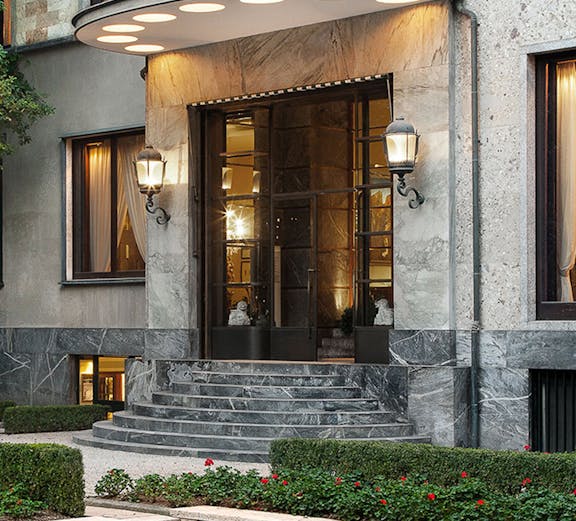 Entrance of Villa Necchi Campiglio in Milan with stone steps and garden.