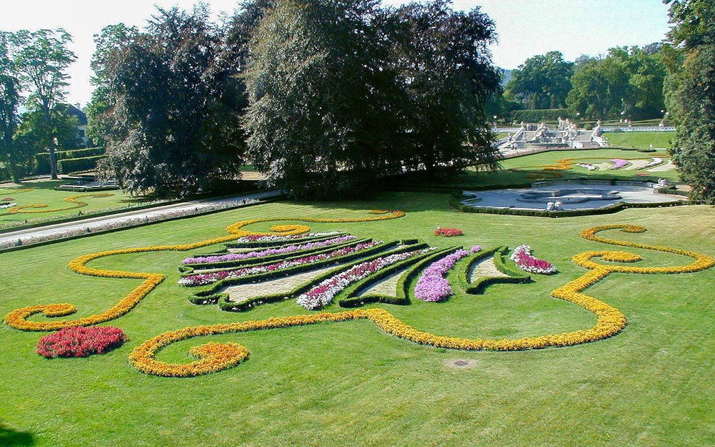 Cesky Krumlov castle gardens with colorful floral designs and manicured lawns.