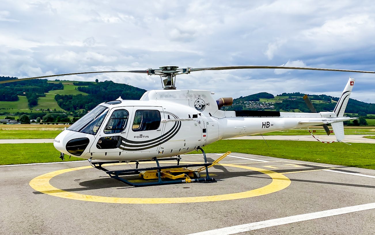 Helicopter on helipad ready for scenic flight over Bernese Seeland and Jura.