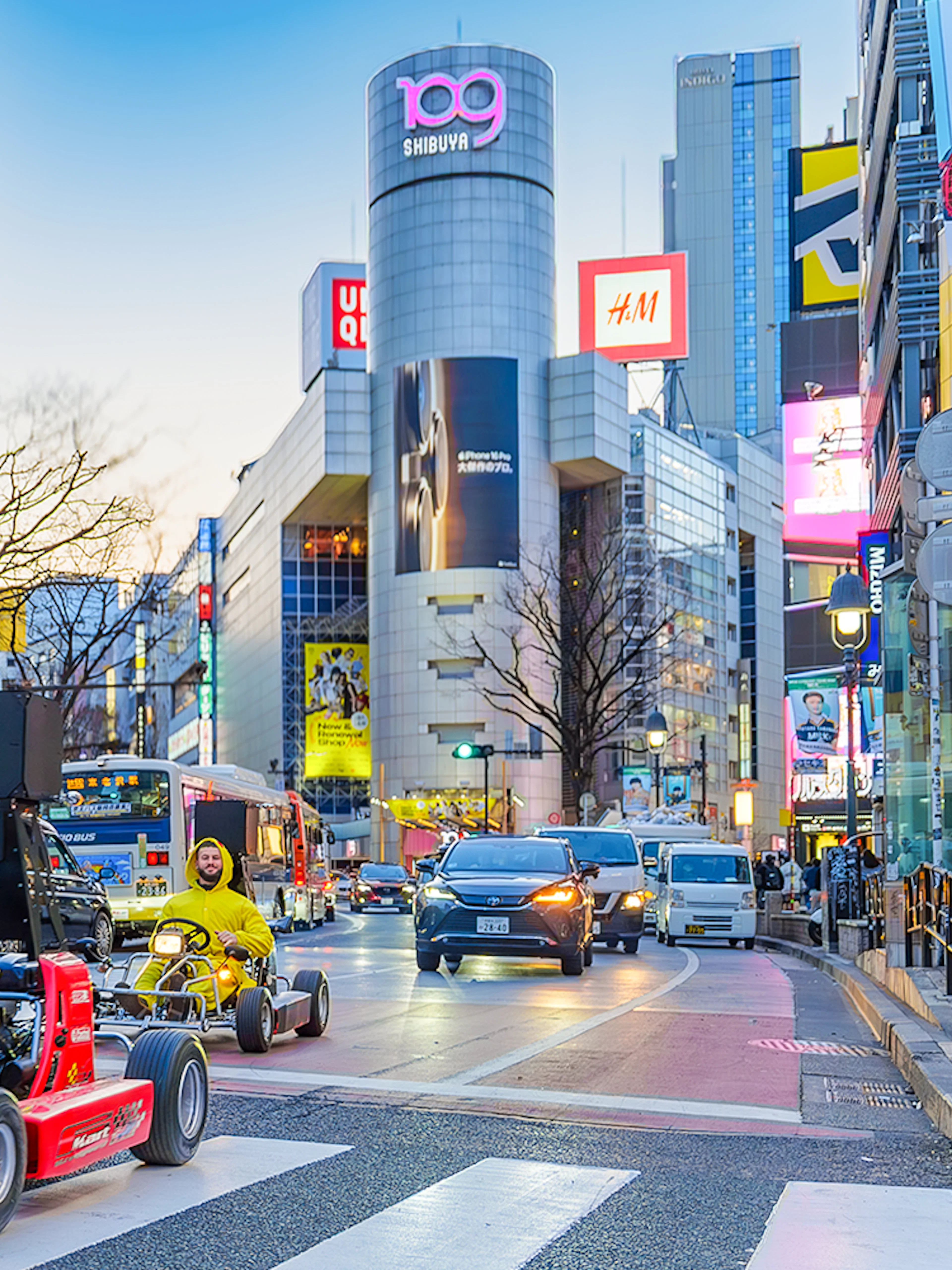 Go-karting on a busy street in Shibuya, Tokyo at dusk.