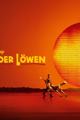 Stage scene from "Der König der Löwen" with performers and animal puppets against a sunset backdrop.