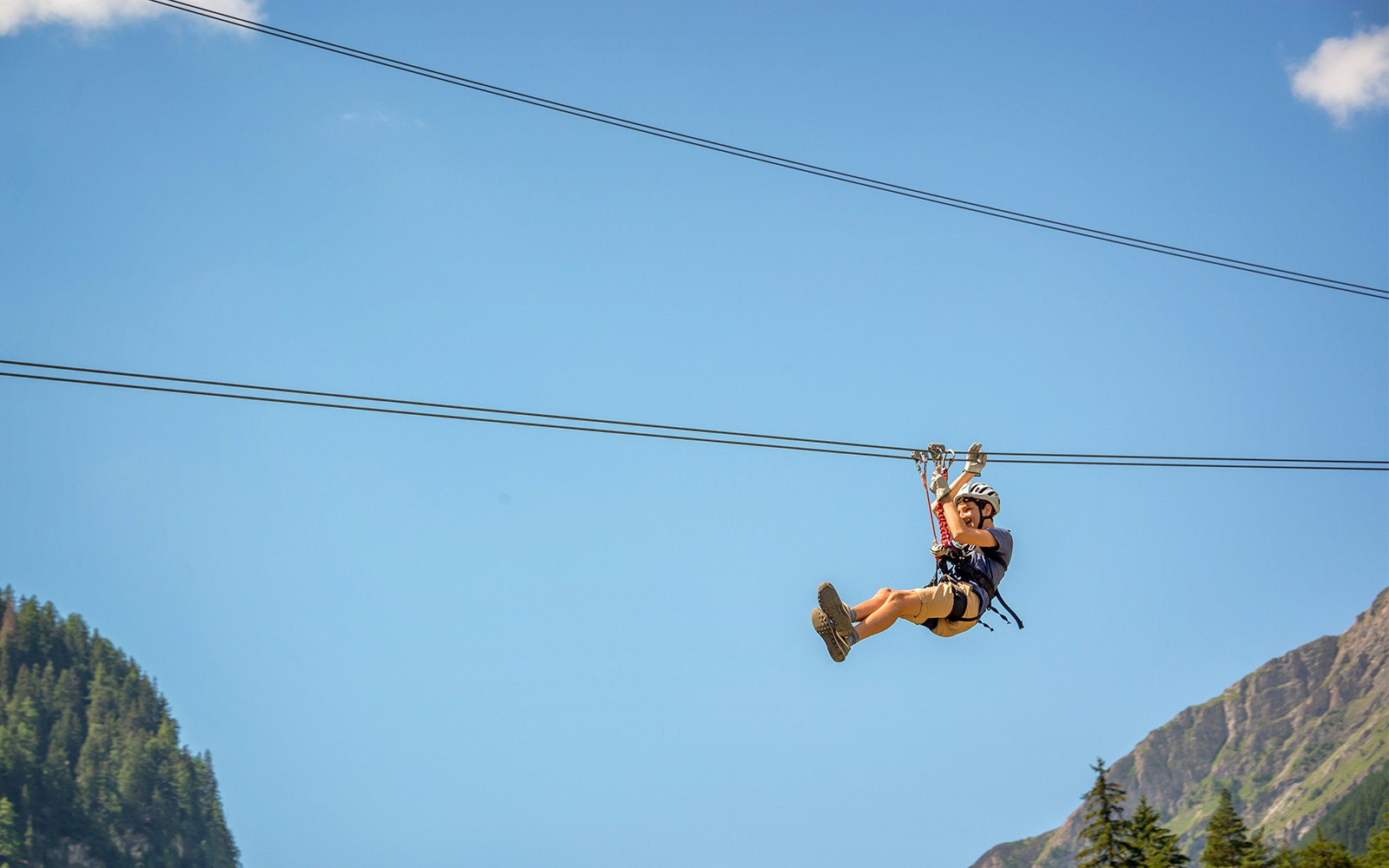 Person ziplining in Grindelwald First with panoramic views of Swiss Alps from Lucerne.