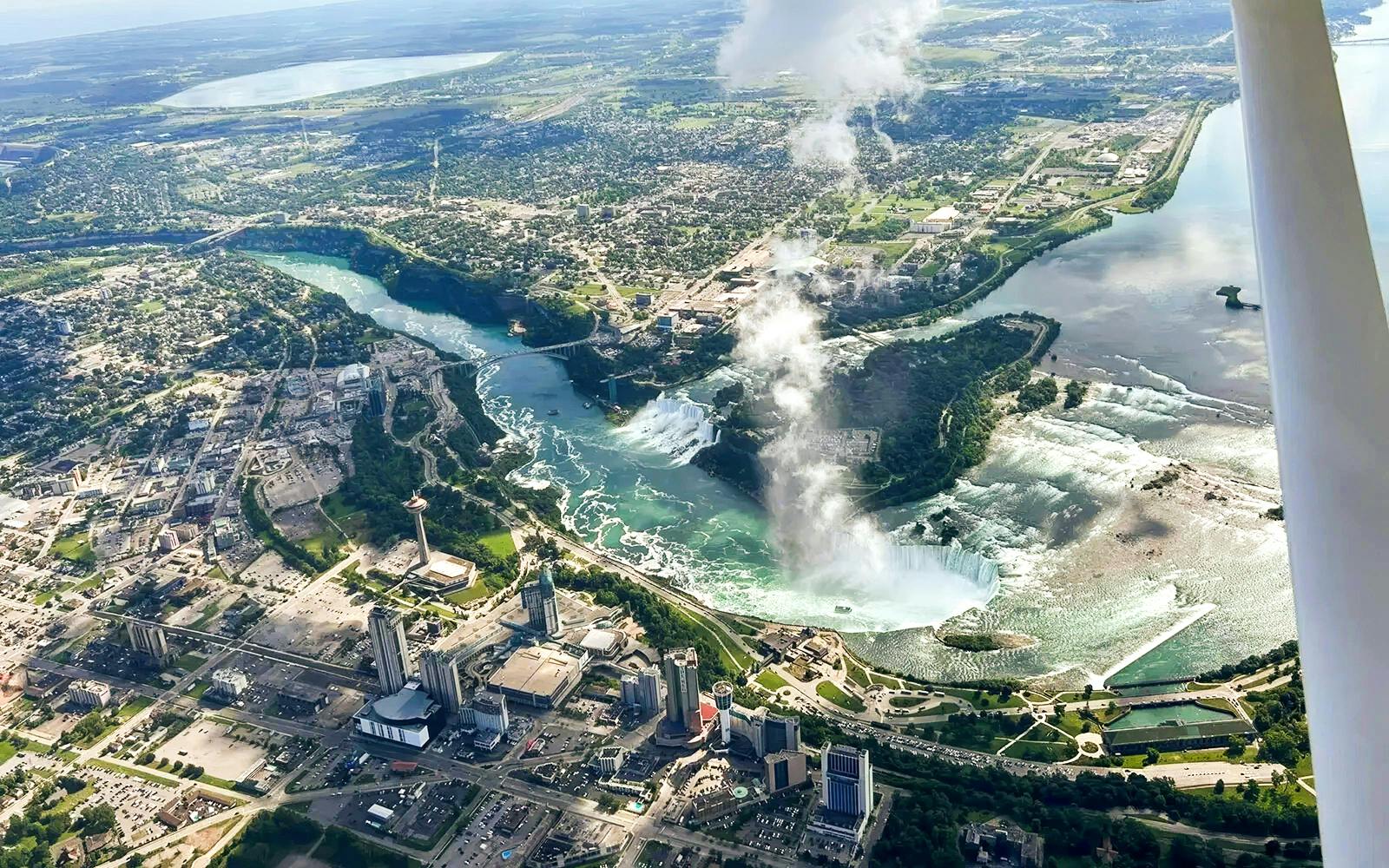 Aerial view of Niagara Falls with surrounding cityscape, highlighting the falls and river.