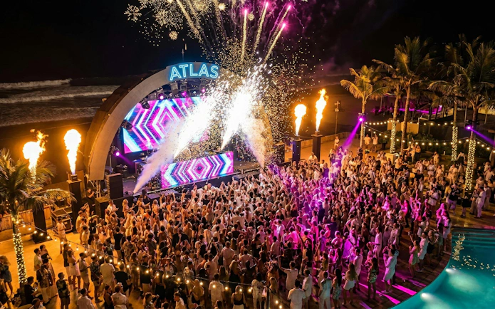 Crowd enjoying New Year’s Eve concert with fireworks at Atlas Beach Club.