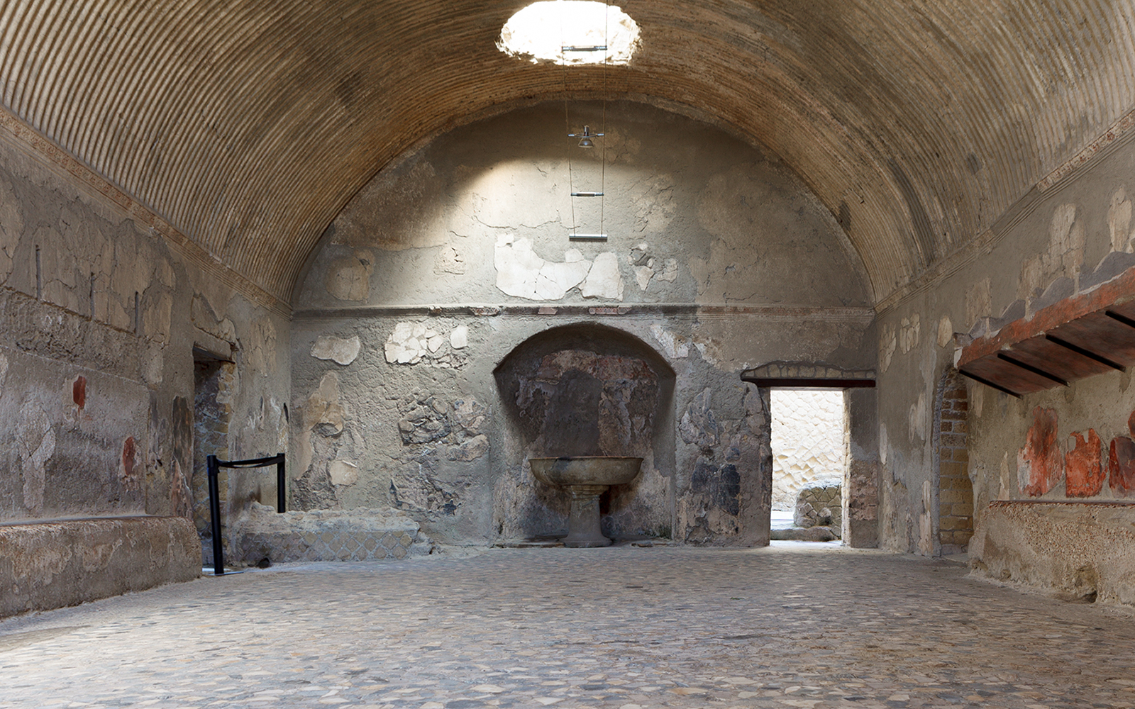 Central Baths interior at Herculaneum with vaulted ceiling and ancient stone basin.