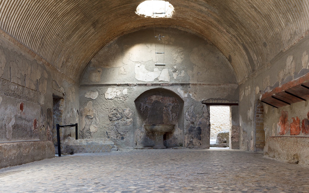 Central Baths interior at Herculaneum with vaulted ceiling and ancient stone basin.