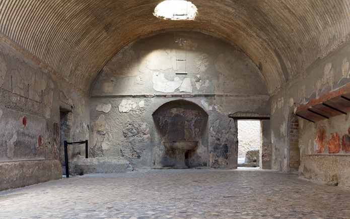 Central Baths interior at Herculaneum with vaulted ceiling and ancient stone basin.