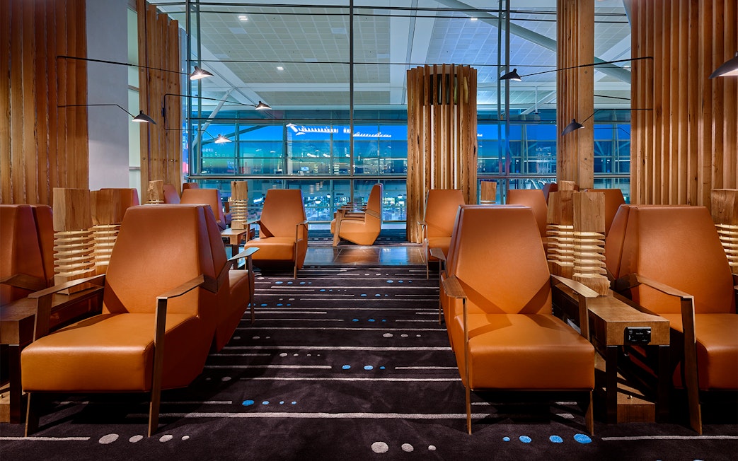 Plaza Premium Lounge seating area with leather chairs and large windows.