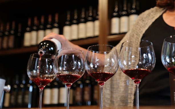 Pouring red wine into glasses during Trastevere food tour.