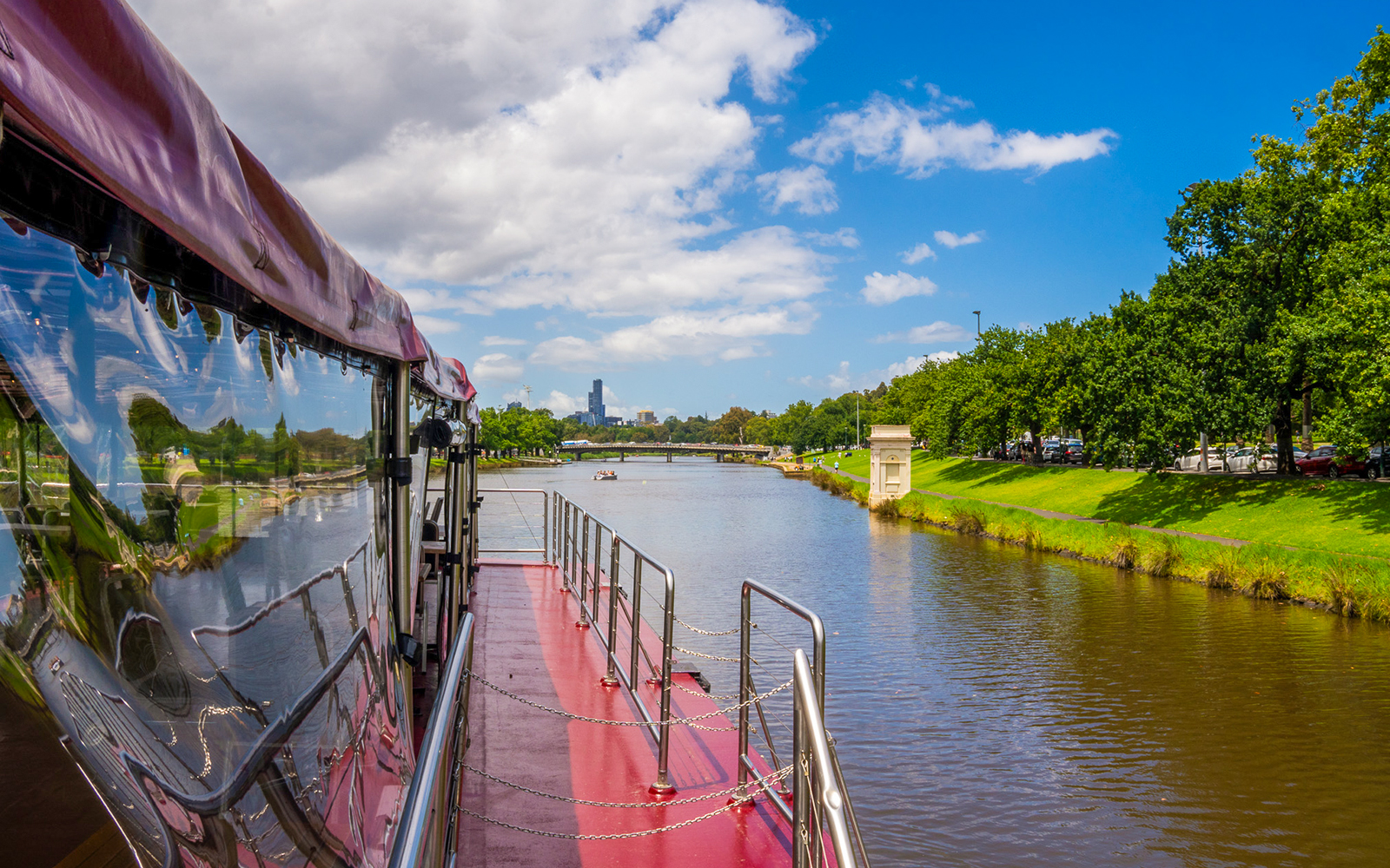 Cruise boat on Yarra River with Melbourne skyline in the background.