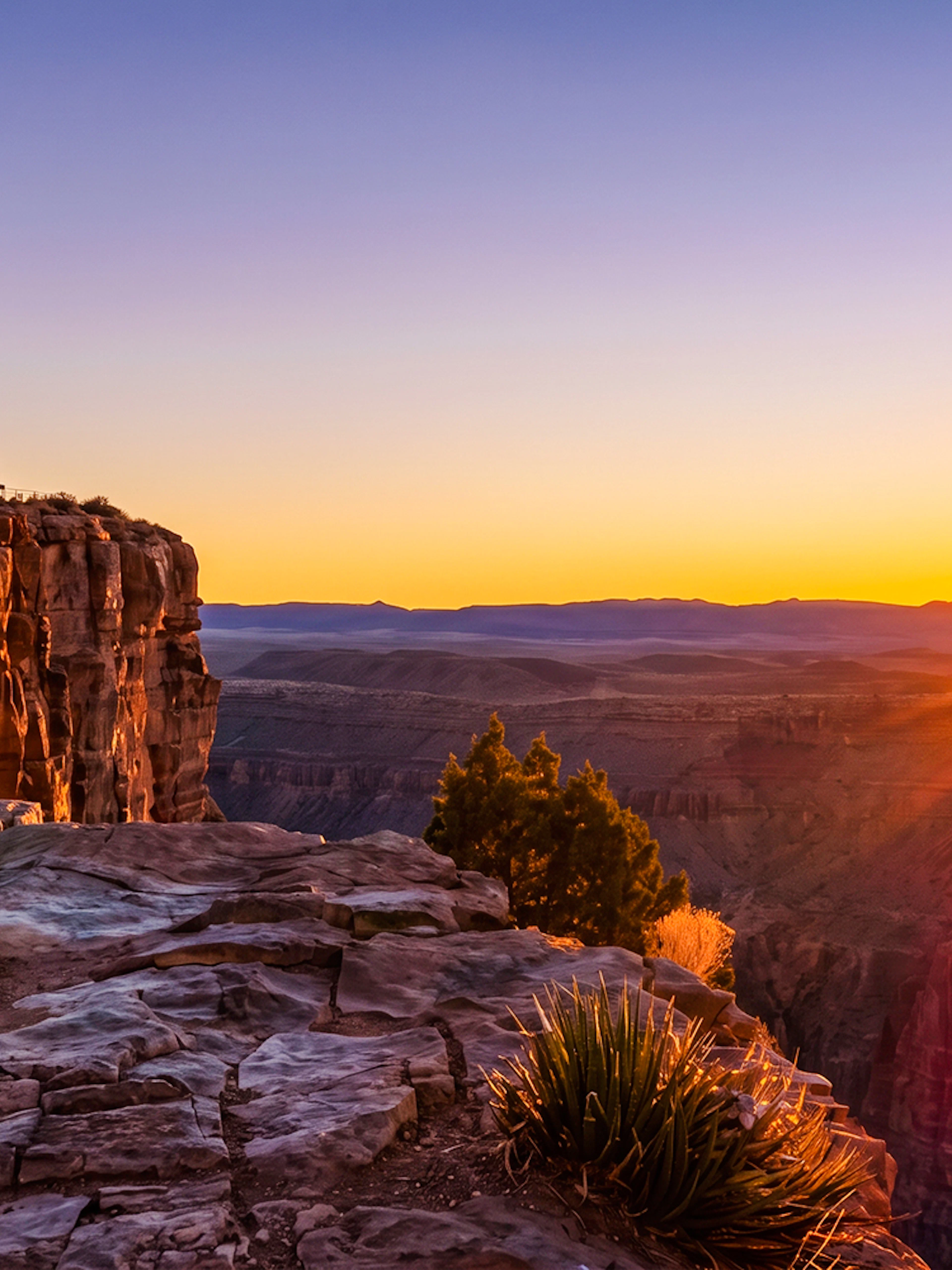 Person standing on Grand Canyon West rim watching sunset.