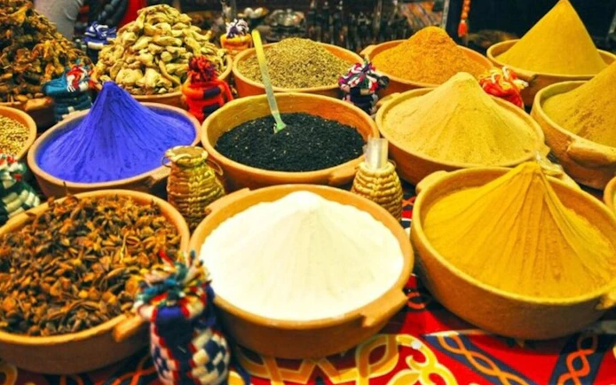 Colorful spices in bowls at a market during a shopping trip from Hurghada.