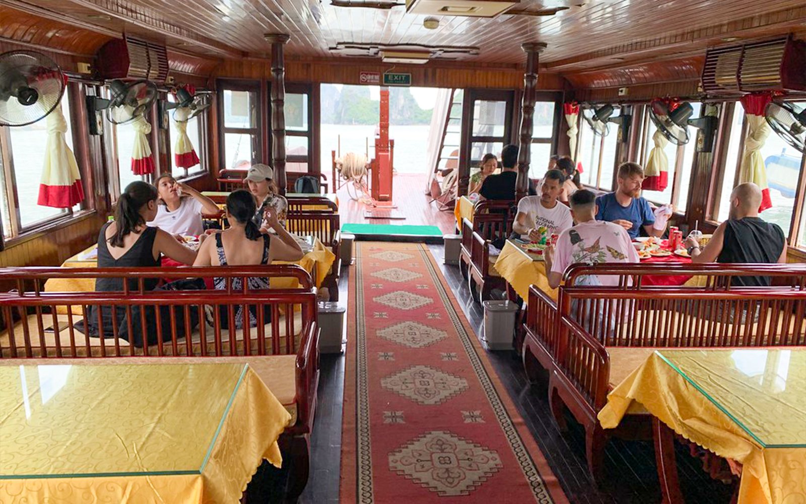 Guests dining inside Dragonfly Standard Cruise restaurant with scenic views.