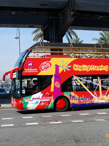 City Sightseeing Genoa hop-on hop-off bus with colorful design.
