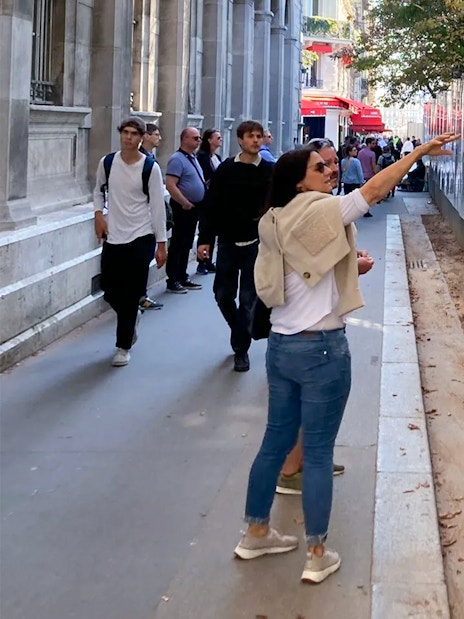 Tourists exploring a historical exhibit on a Paris street during a guided tour.