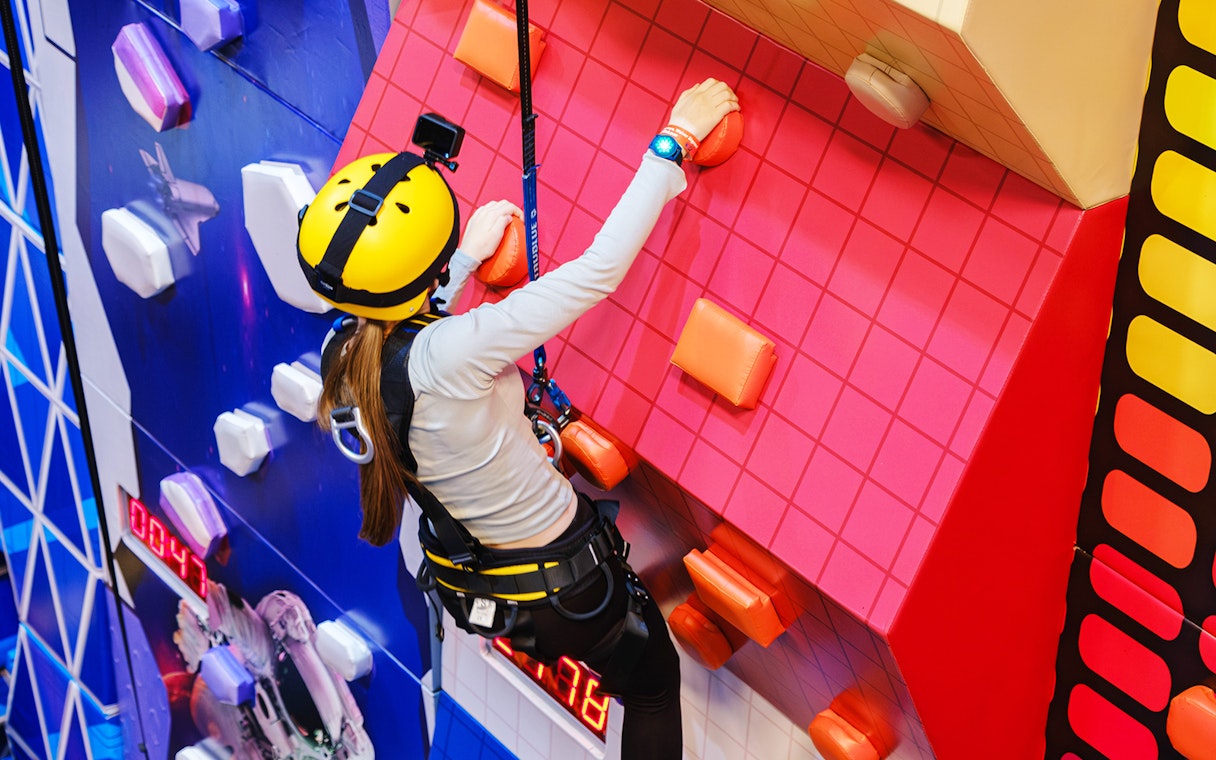 Climber on indoor wall at Loco Bear Entertainment Hub.