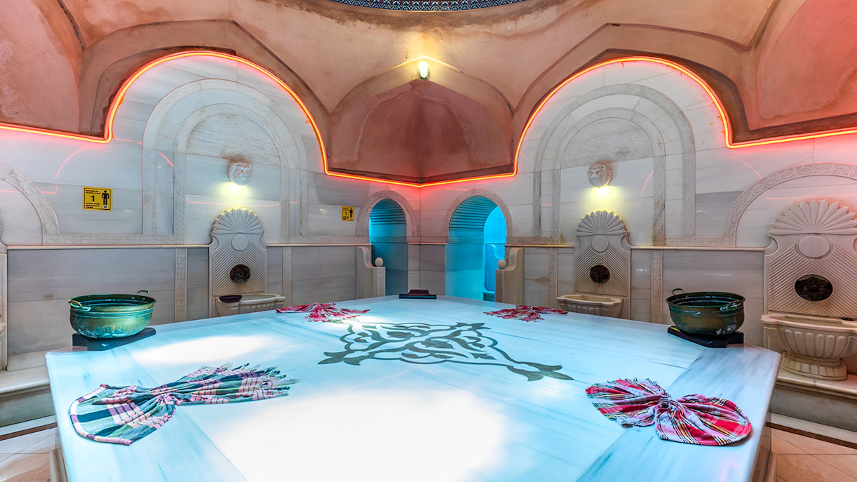 Inside Acemoglu Hammam, Turkey, featuring marble basins and traditional decor.