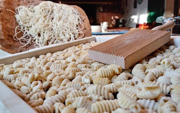 Freshly made pasta and a wooden gnocchi board in a cooking class in Alghero.