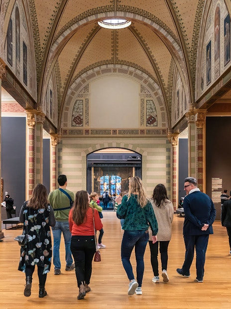 Visitors exploring the Rijksmuseum's ornate gallery during a guided tour in Amsterdam.