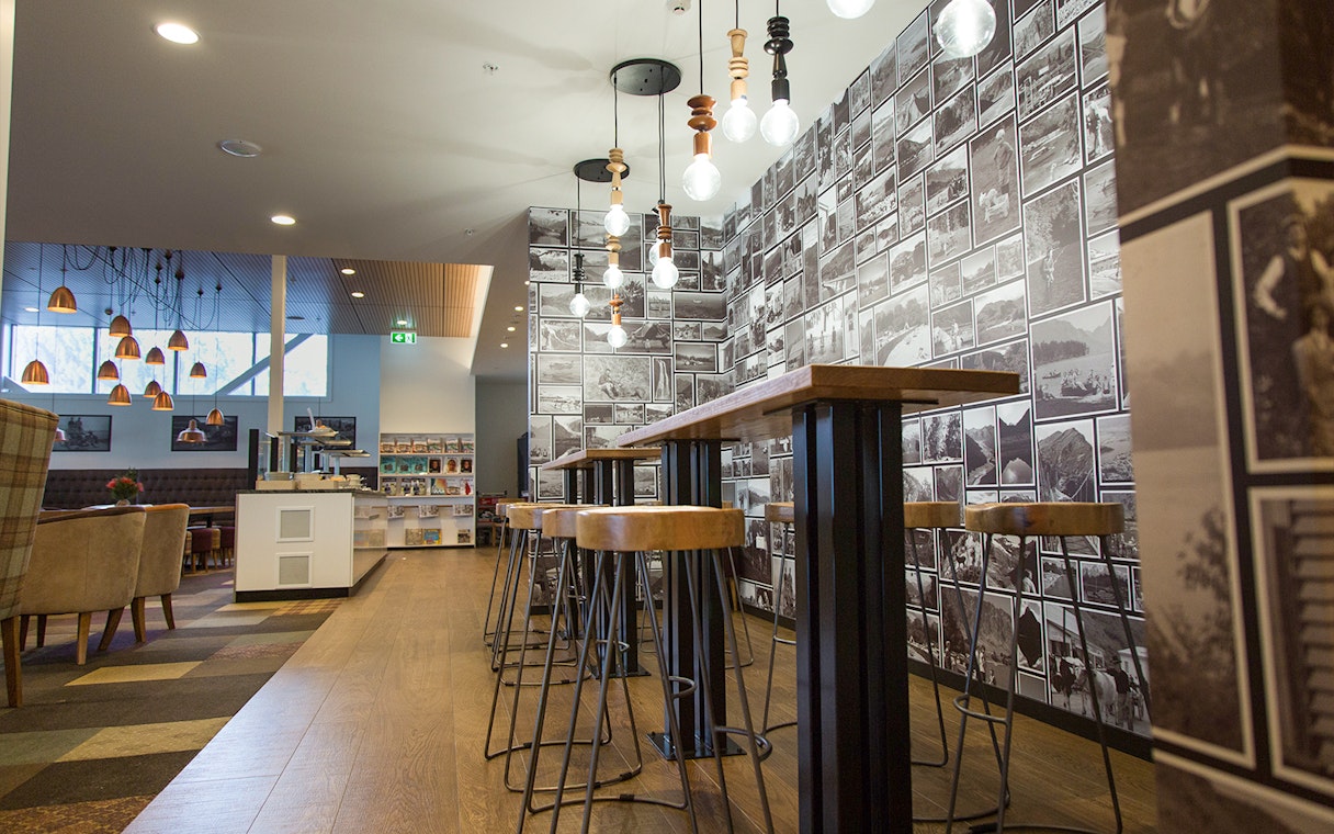 Plaza Premium Lounge seating area with high tables and photo wall display.