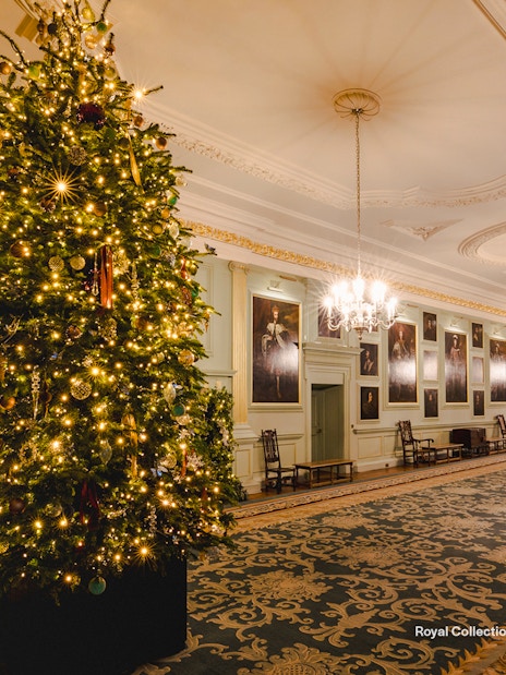 Palace of Holyroodhouse grand hall with Christmas tree and festive decorations.