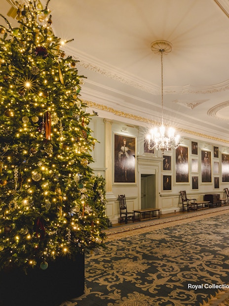 Palace of Holyroodhouse grand hall with Christmas tree and festive decorations.