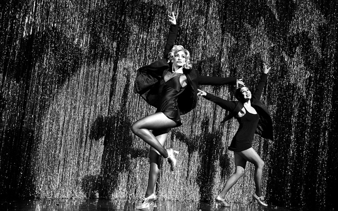 Performers dancing on stage in a Chicago musical show.