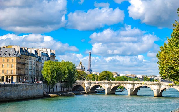 Paris Seine River with Pont Neuf bridge and Eiffel Tower in the background.