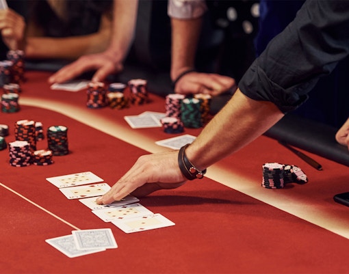 Poker game in progress at Casino with players and chips on the table.