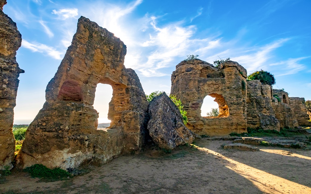 Ancient stone ruins with arched openings in Valley of the Temples, Sicily.