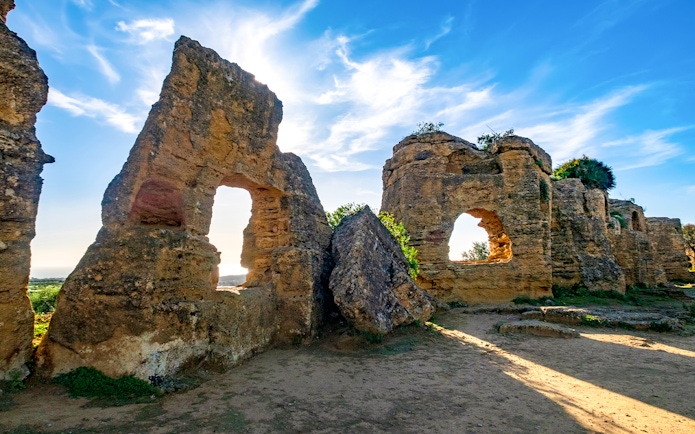 Ancient stone ruins with arched openings in Valley of the Temples, Sicily.